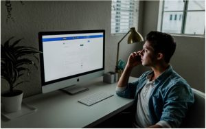 Employee talking to his team leader on the phone about their organization's transition from fax machines to online faxing service.